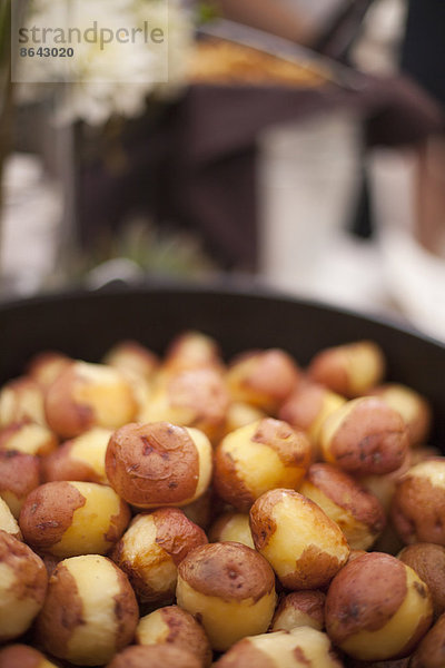 Ein Hochzeitsbuffet. Ein Gericht mit teilweise geschälten neuen Kartoffeln.