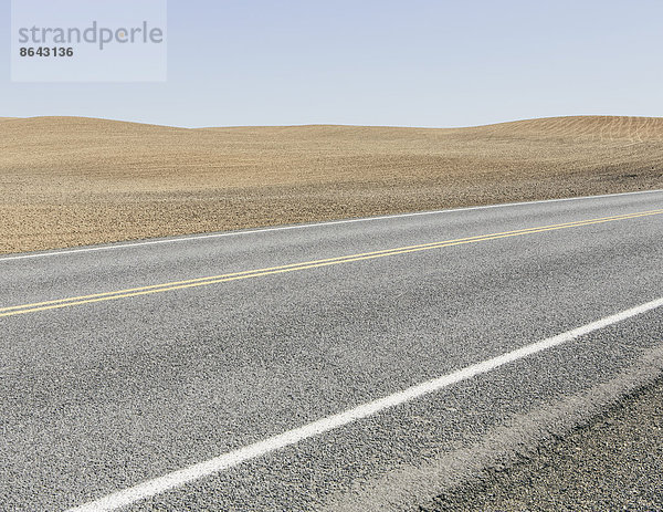 Straße durch gepflügtes Ackerland in der Nähe von Pullman