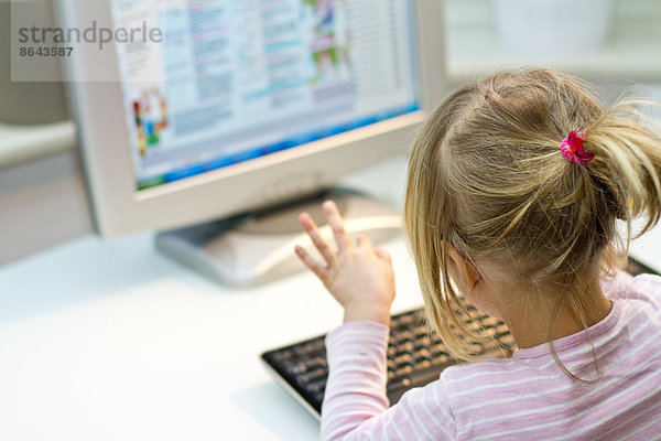 Blondes Mädchen vor einem Computer