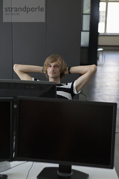 Mann entspannt am Computertisch