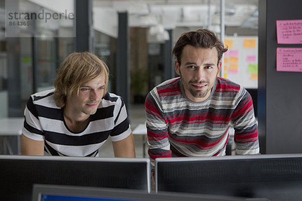 Zwei Männer bei der Arbeit am Computer im Büro