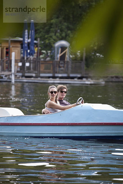 Junges Paar beim Tretbootfahren auf dem See