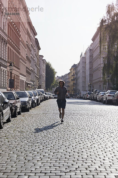 Mittlerer Erwachsener Mann beim Joggen durch die Straße