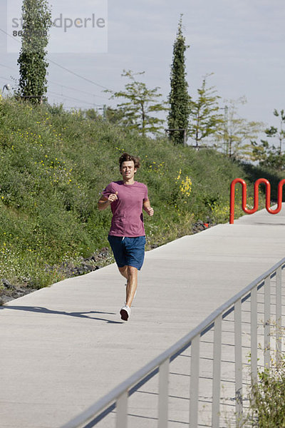 Mittlerer Erwachsener Mann beim Joggen auf dem Fußweg