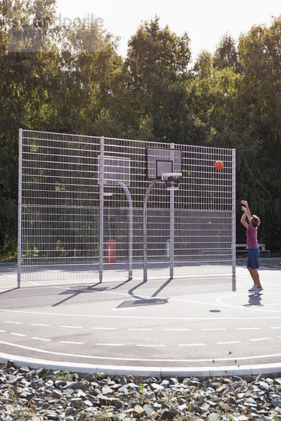 Mittlerer Erwachsener Mann spielt Basketball