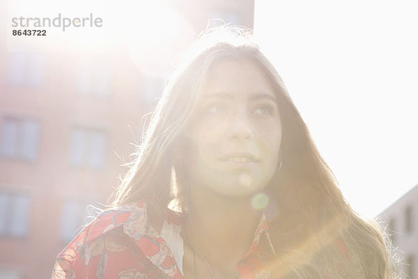 Junge Frau unter der Sonne stehend  Nahaufnahme