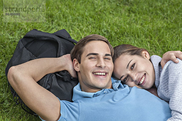 Portrait eines jungen Paares auf Gras liegend