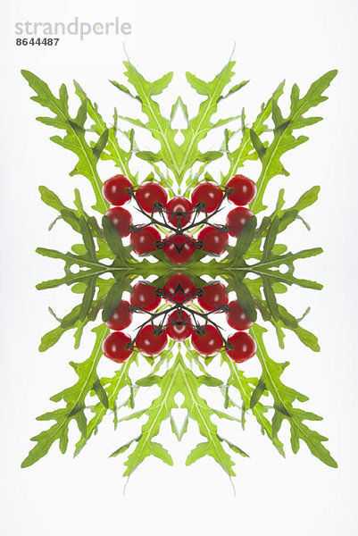 Eine digitale Komposition aus Spiegelbildern von roten Johannisbeeren und Rucola-Blättern.