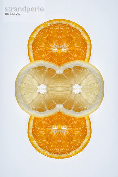 Ein digitaler Verbund von Spiegelbildern von Orangen- und Zitronenscheiben