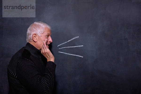 Porträt eines älteren Mannes vor der Tafel