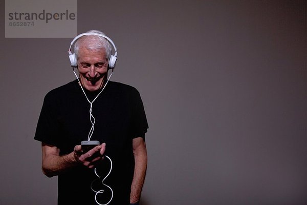 Portrait eines älteren Mannes mit Kopfhörer und MP3-Player
