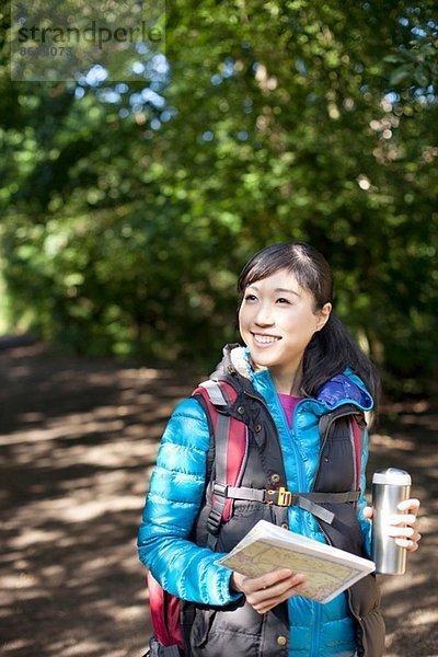 Junge Wanderin mit Karte und Flasche