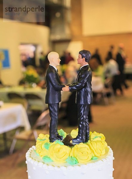 Paar männliche Figuren auf der Hochzeitstorte beim Empfang