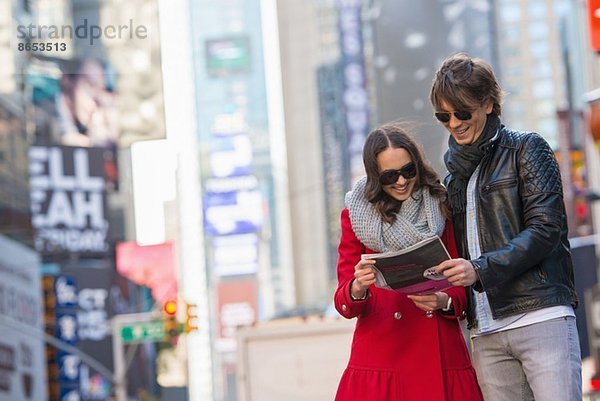 Junges Touristenpaar auf der Suche nach einer Zeitung  New York City  USA