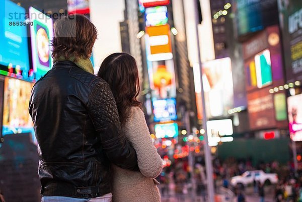 Junges Paar schaut auf Neonschilder  New York City  USA