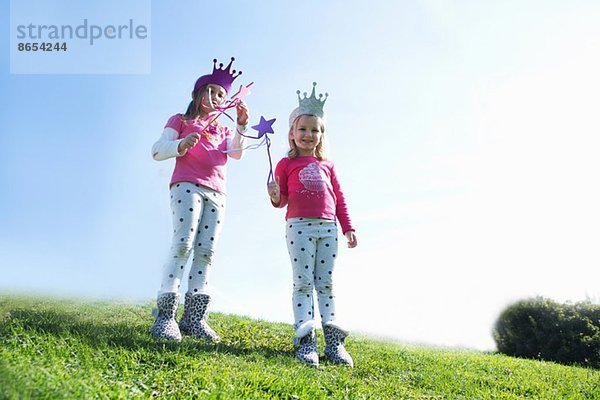 Zwei junge Schwestern  verkleidet als Feen auf dem Hügel.