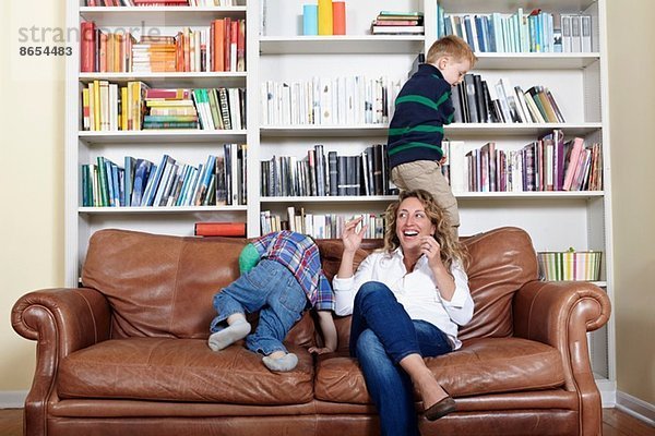 Mutter und kleine Söhne beim Spielen auf dem Sofa