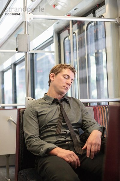 Mittlerer Erwachsener Büroangestellter schlummert auf Zugfahrt
