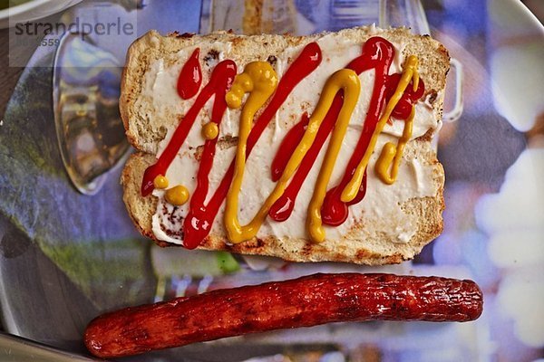 Stilleben von Brötchen  Senf  Tomatensauce und Hotdog-Wurst