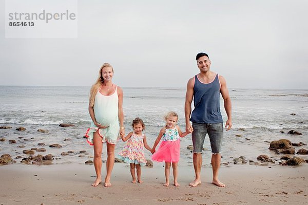 Eltern und zwei junge Mädchen beim Strandspaziergang