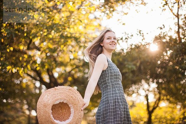 Teenagermädchen mit Sonnenhut im Park