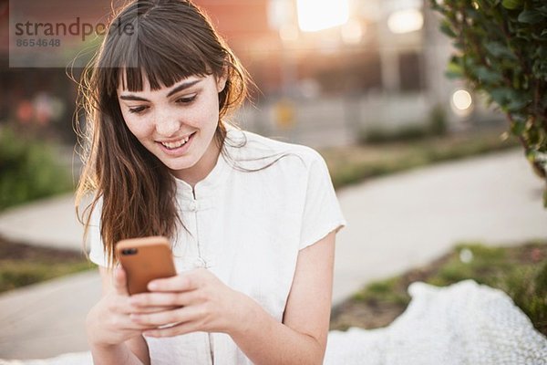 Junge Frau beim SMSen auf dem Handy