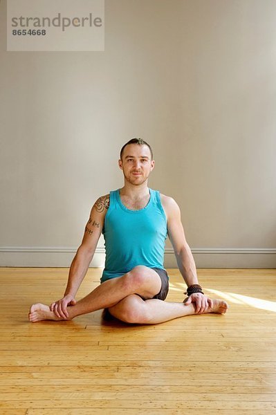 Mann in Kuhgesicht-Yoga-Pose