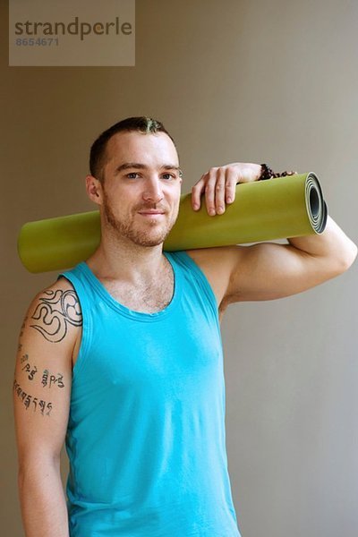 Porträt eines Mannes mit Yogamatte