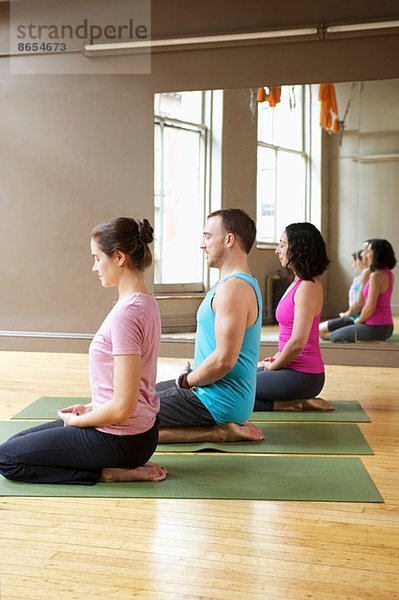 Menschen knien in der Yogastunde