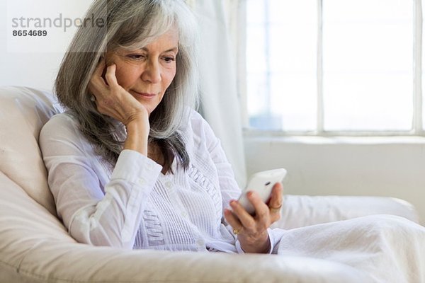 Seniorin schaut auf Smartphone