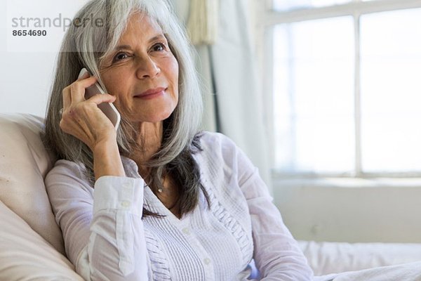 Porträt der attraktiven Seniorin im Chat auf dem Smartphone