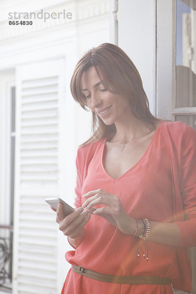 Frau auf dem Balkon mit Smartphone