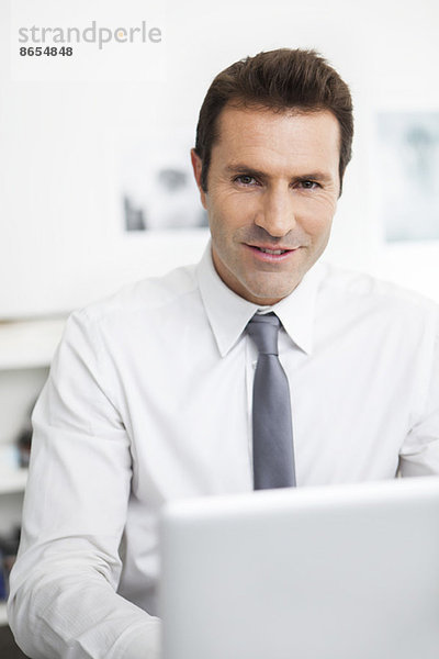 Geschäftsmann mit Laptop bei der Arbeit im Büro