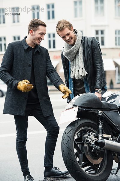 Mann mit Freund zeigt auf Motorrad