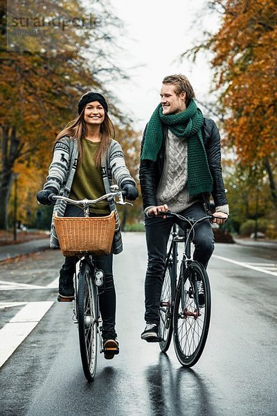 Junges Paar beim Radfahren auf der Straße