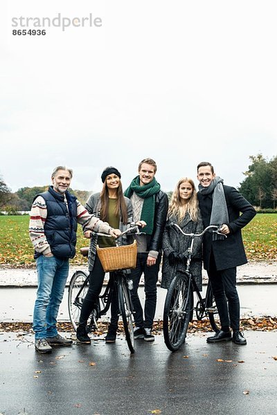 Freunde posieren mit dem Fahrrad auf der Straße