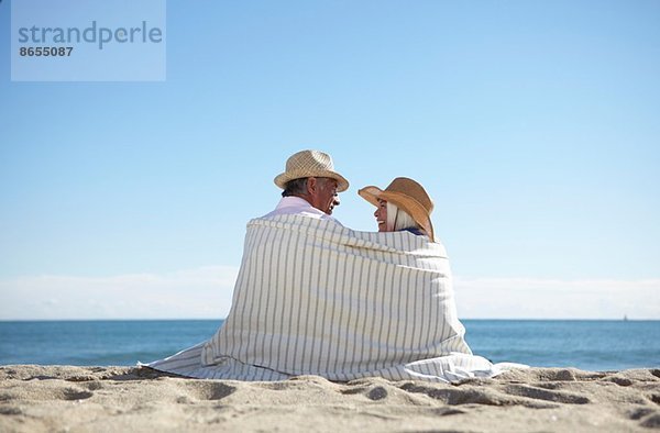 Paar mit Strohhut am Strand