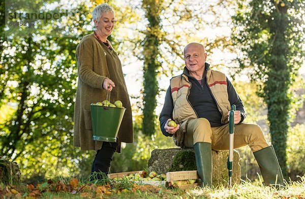 Seniorenpaar macht eine Pause im Obstgarten