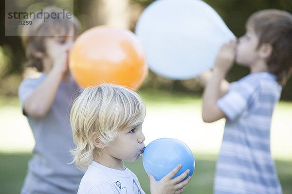 Jungen blasen Luftballons