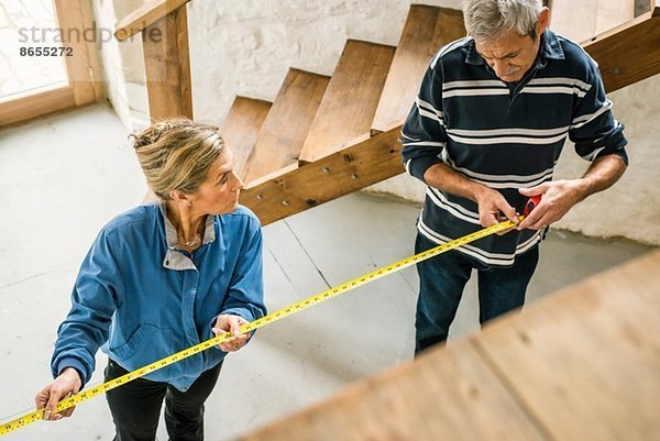 Älteres Ehepaar beim Heimwerken  mit Maßband