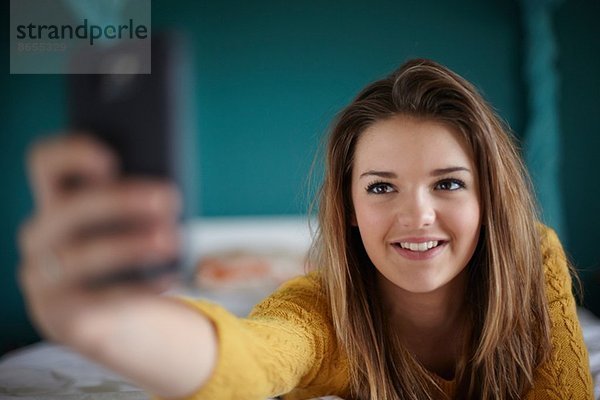 Teenager-Mädchen im Schlafzimmer mit einem Selfie