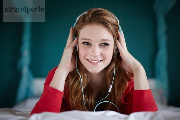 Porträt eines Mädchens im Schlafzimmer beim Musikhören