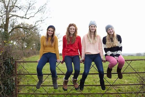 Vier Teenager-Mädchen sitzen am Tor.