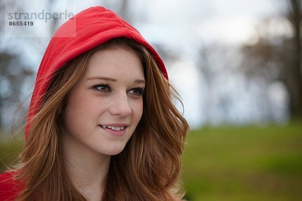 Outdoor-Porträt eines Teenager-Mädchens in roter Kapuze