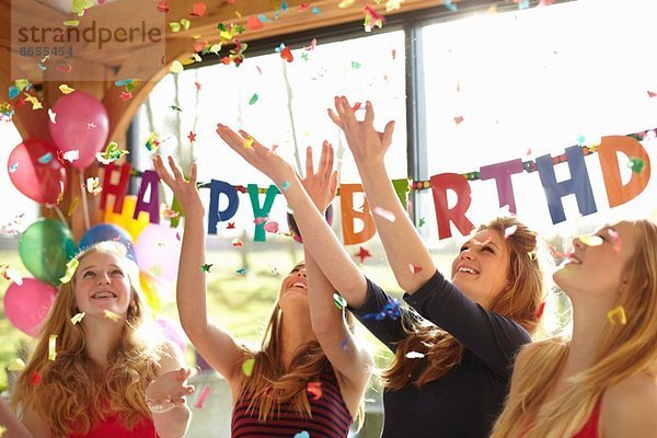 Vier Teenager-Mädchen feiern mit Konfetti auf der Geburtstagsfeier