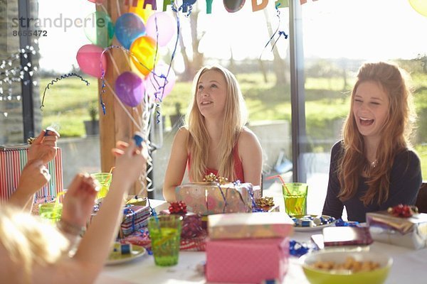 Vier Teenager-Mädchen feiern mit Blasen auf der Geburtstagsfeier
