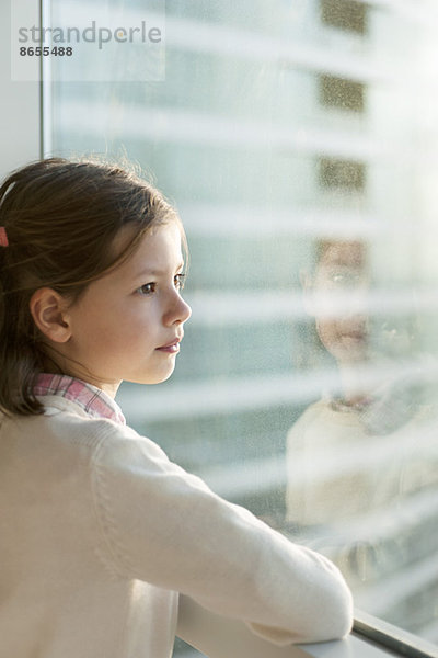 Mädchen schaut aus dem Fenster  Portrait