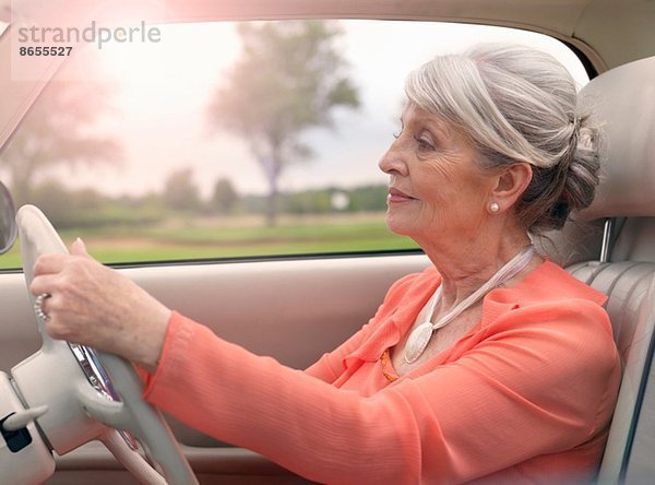 Elegante Seniorin beim Autofahren