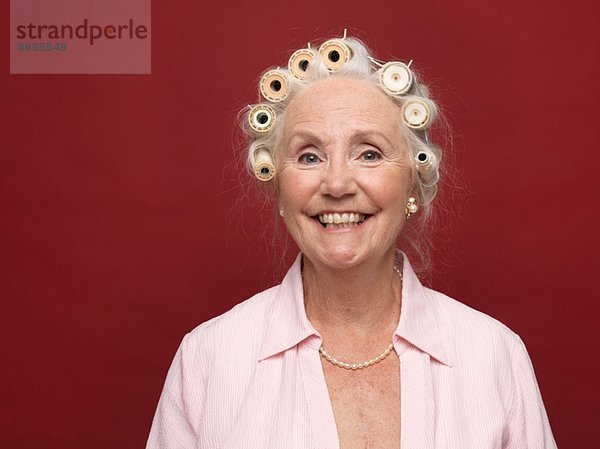 Studio-Porträt einer älteren Frau in Haarrollen