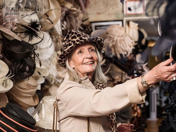 Glamouröse Seniorin beim Blick auf Hüte